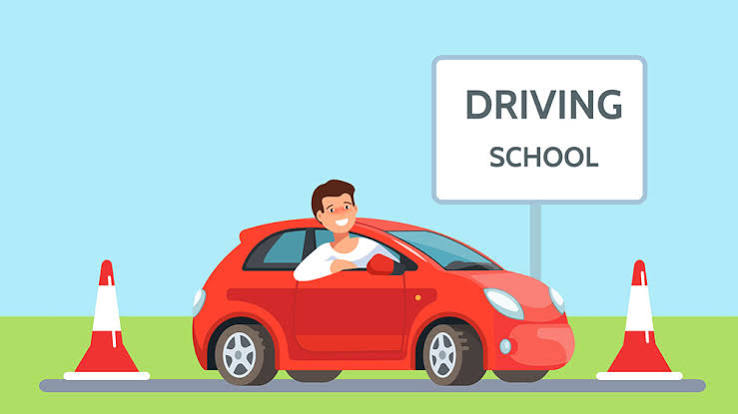Learner car between traffic cones beside a driving school sign
